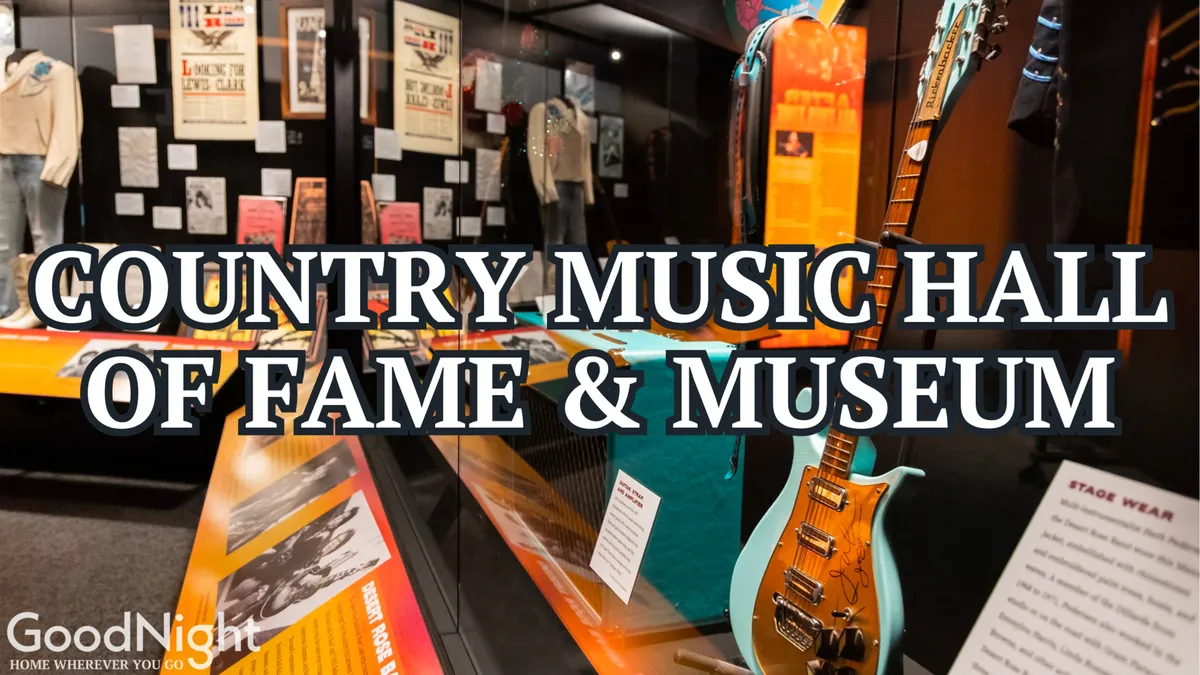 Interior exhibits at the Country Music Hall of Fame, with country music memorabilia, a prominently displayed guitar, and informational plaques. Visitors can be seen engaging with the interactive and historical displays.